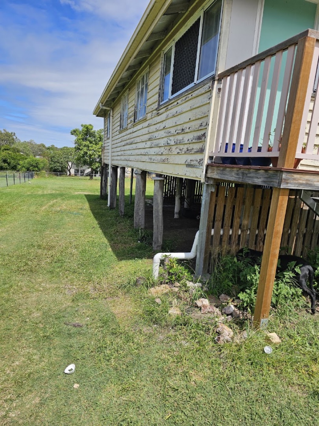 A high-set house on stumps with a timber deck and balustrade
