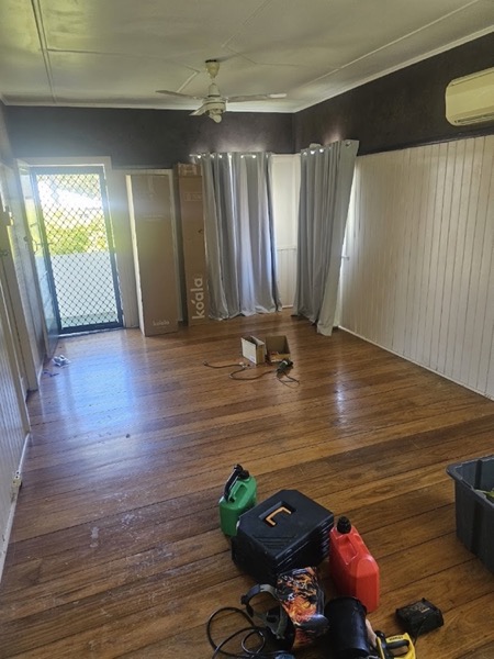 An empty room with polished timber floors and timber lining boards
