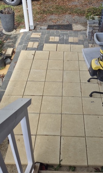 A paved tiled patio beside a timber handrail