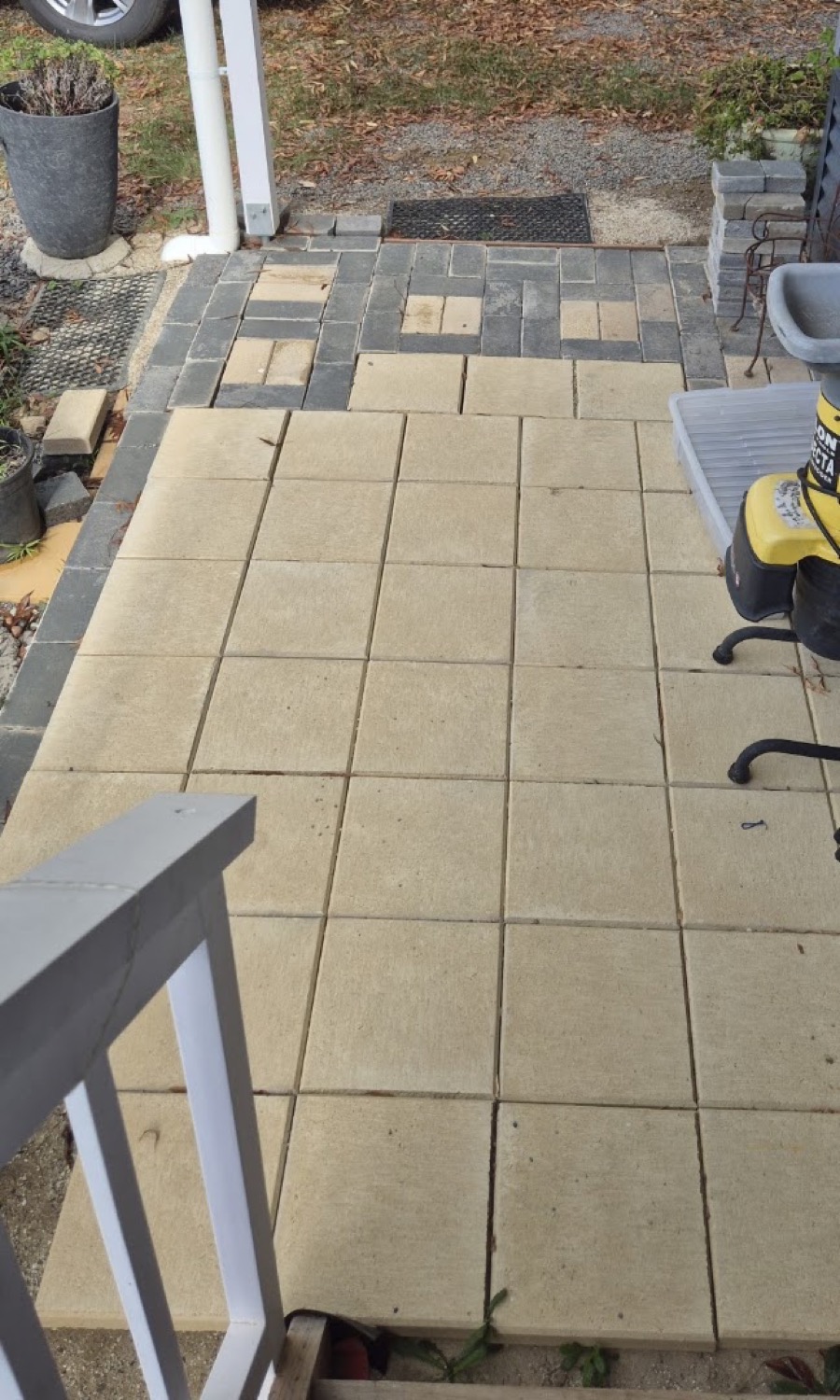 A paved tiled patio beside a timber handrail